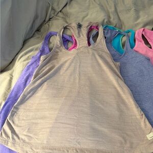 Set of 7 lululemon and Vuori Tank Tops in Purple, Pink, and Blue. Size 6 and 4s.